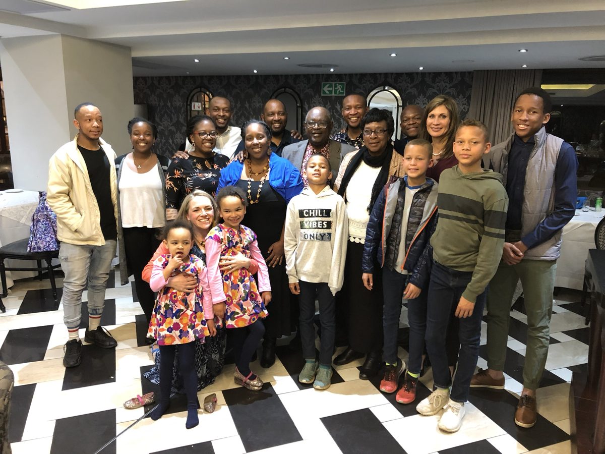Large family group photo with children and adults at a restaurant